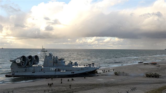 A picture taken on September 26, 2013, shows a Russian Navy Zubr class hovercraft unloading armoured personnel carriers on the seashore during a joint military exercises of Russian and Belarus troops at the Khmelevka firing range in the Russia’s enclave of Kaliningrad.