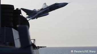 jet flying past naval ship © Reuters/US Navy