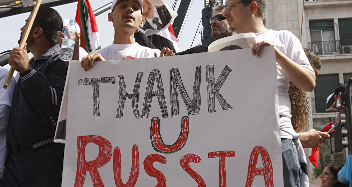 In this Oct. 12, 2011 file photo, supporters of the Syrian government hold a pro-Russian banner to show their support for President Bashar Assad and to thank Russia and China for blocking a U.N. Security Council resolution condemning Syria for its brutal crackdown, during a demonstration in Damascus, Syria.