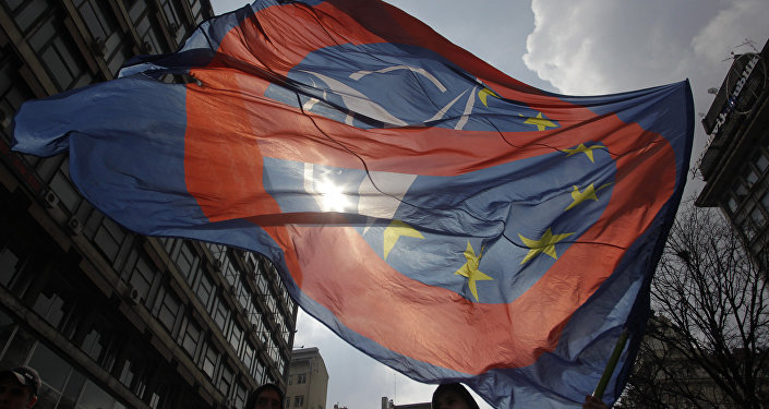 A man waves an anti NATO and EU flag during an anti NATO rally in downtown Belgrade, Serbia, March 27, 2016.