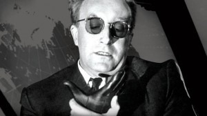 Peter Sellers playing Dr. Strangelove in the 1964 film of that name. Dr. Strangelove struggles to control his right arm from making a Nazi salute