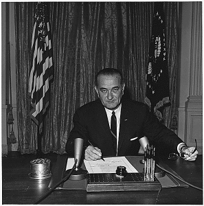 President Lyndon B. Johnson signs the Gulf of Tonkin resolution, Aug 10, 1964, authorizing him to wage unlimited war in Vietnam